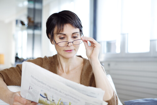 Woman with eyeglasses reading the newspaper